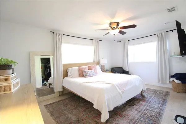 a bedroom with a large bed and a chandelier