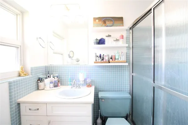 a bathroom with a sink a toilet and a large mirror