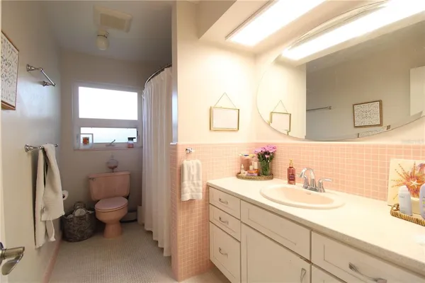 a bathroom with a sink toilet and a mirror