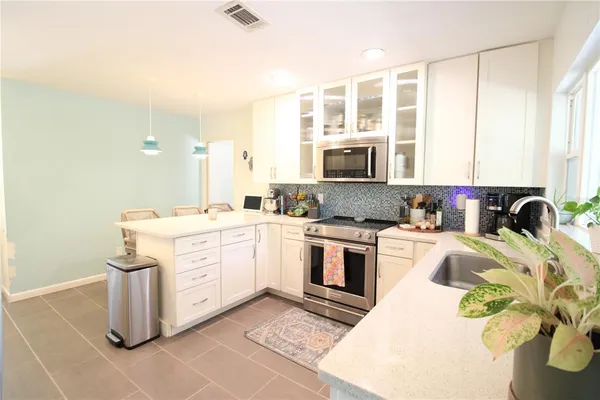 a kitchen with a stove a sink and a refrigerator