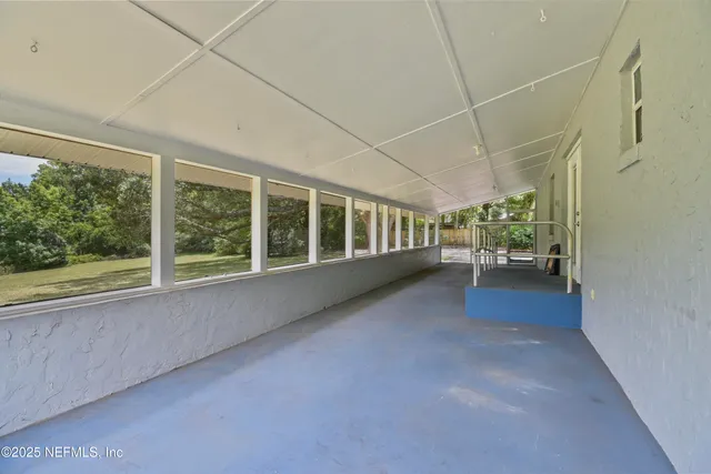 a view of hallway with a floor to ceiling window and a room