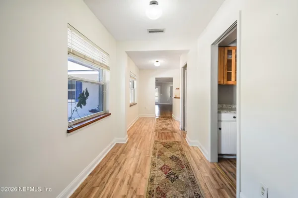 a view of a hallway with wooden floor and bedroom view