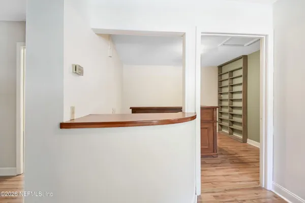 a view of a bedroom with wooden floor and windows