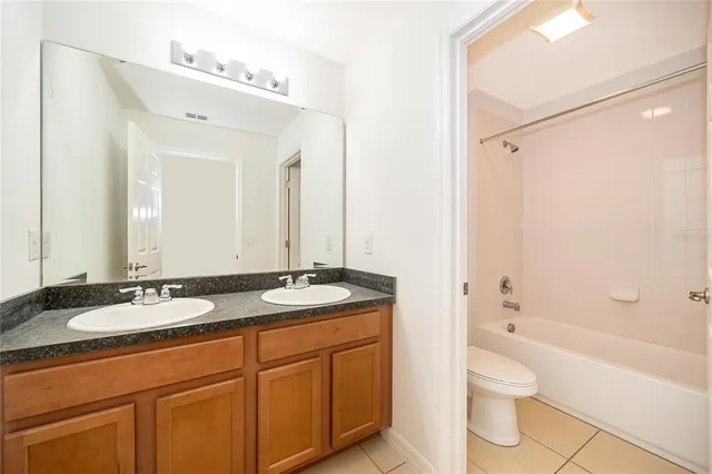 a bathroom with a granite countertop sink toilet mirror and shower