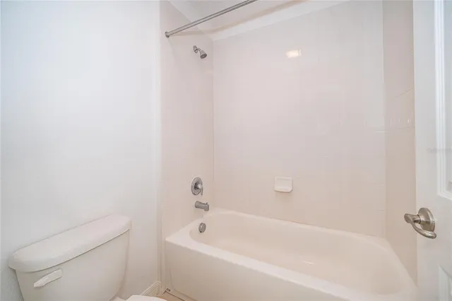 a white bath tub sitting next to a white toilet and sink