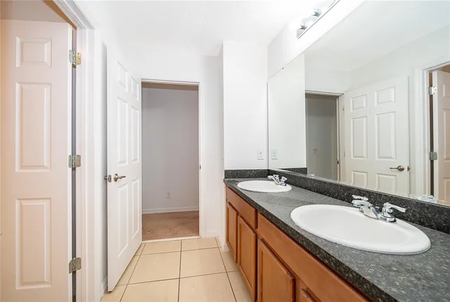a bathroom with a granite countertop sink and a mirror