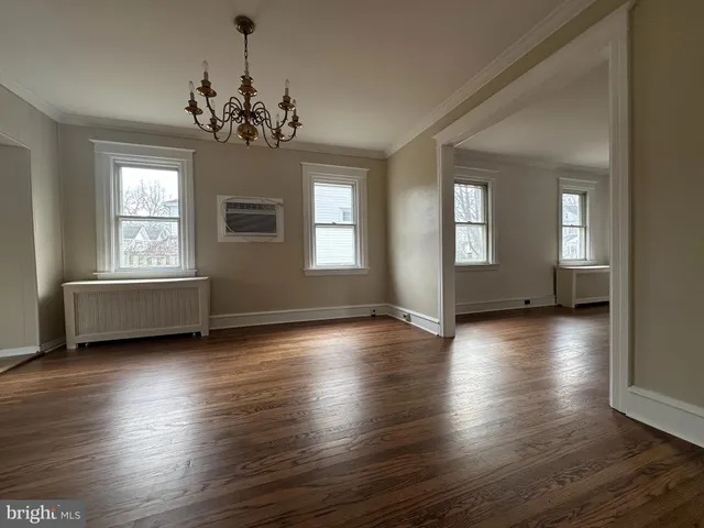a view of a room with wooden floors and windows