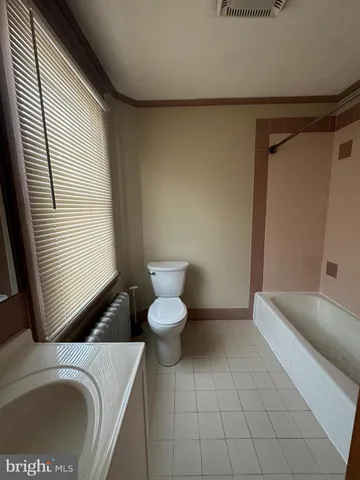 a bathroom with a sink a toilet and a window
