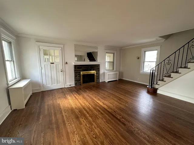an empty room with wooden floor and fireplace