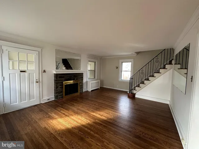 a view of empty room with wooden floor and fireplace