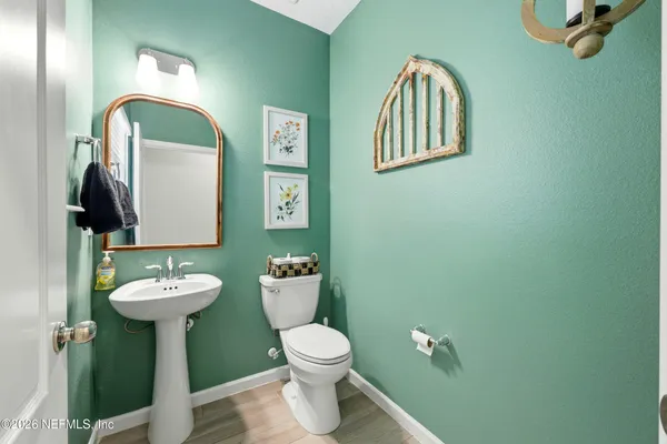 a bathroom with a toilet sink and mirror