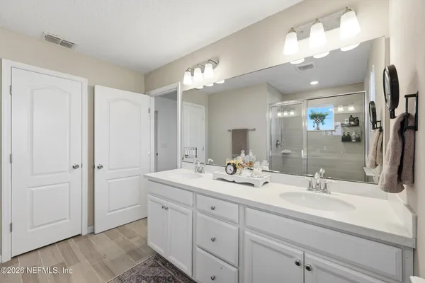 a bathroom with a double vanity sink and a mirror