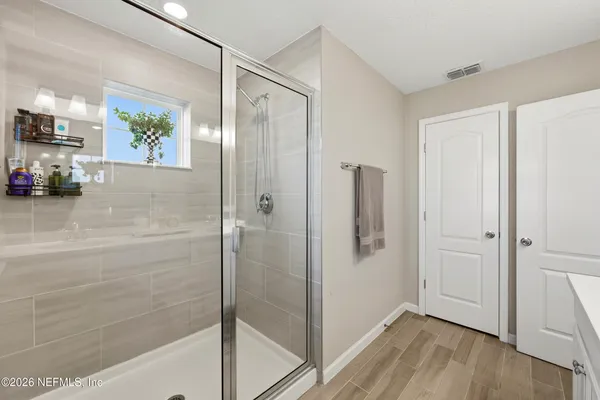 a bathroom with a shower and a glass door