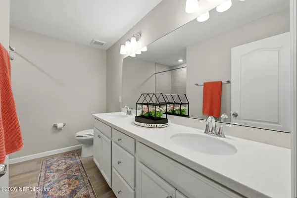 a bathroom with a sink a toilet and a mirror