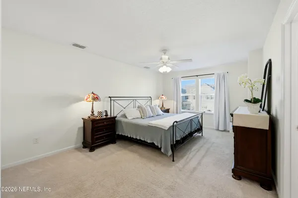 a spacious bedroom with a bed and a flat screen tv