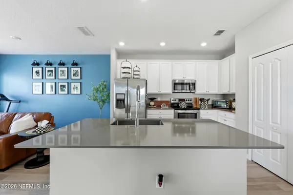 a kitchen with stainless steel appliances granite countertop a refrigerator a stove a sink a microwave and island