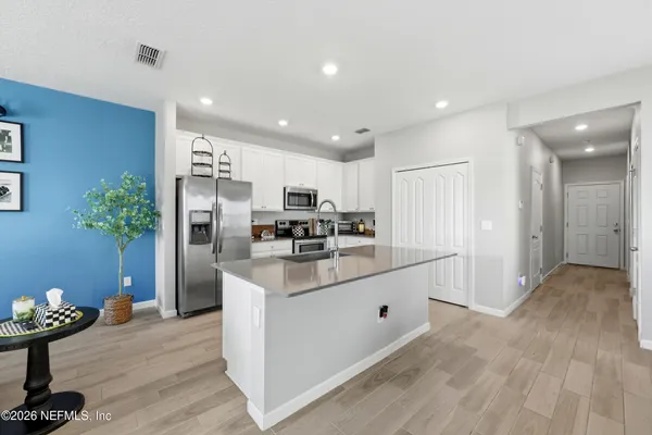 a kitchen with stainless steel appliances kitchen island granite countertop a refrigerator and a sink