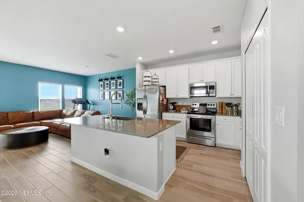 a large white kitchen with stainless steel appliances