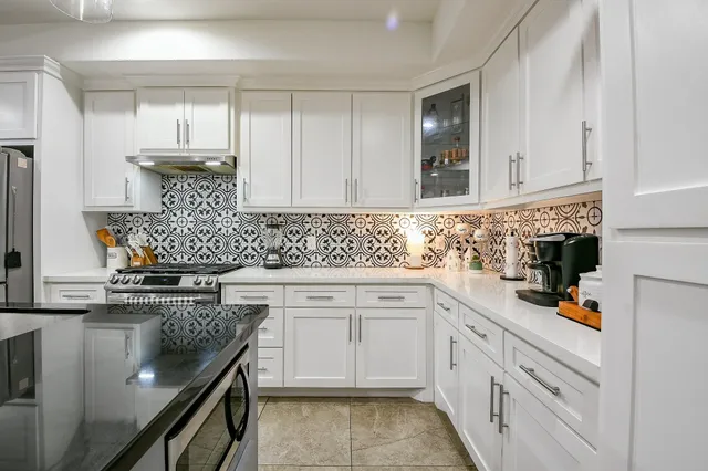 a kitchen with stainless steel appliances granite countertop a sink stove and cabinets