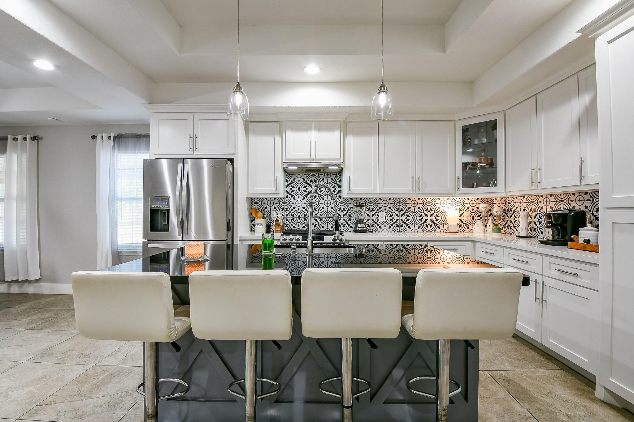 910 11th Street South Houston, TX 77587 - Photo 14 of 32 a kitchen with stainless steel appliances granite countertop a dining table chairs refrigerator microwave and cabinets