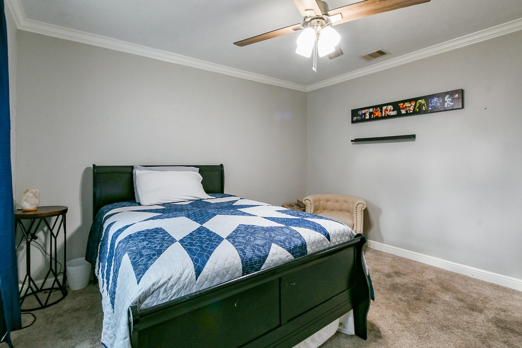 910 11th Street South Houston, TX 77587 - Photo 26 of 32 a bedroom with a bed and a chandelier