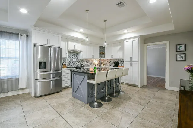 a kitchen with kitchen island a counter top space cabinets and stainless steel appliances