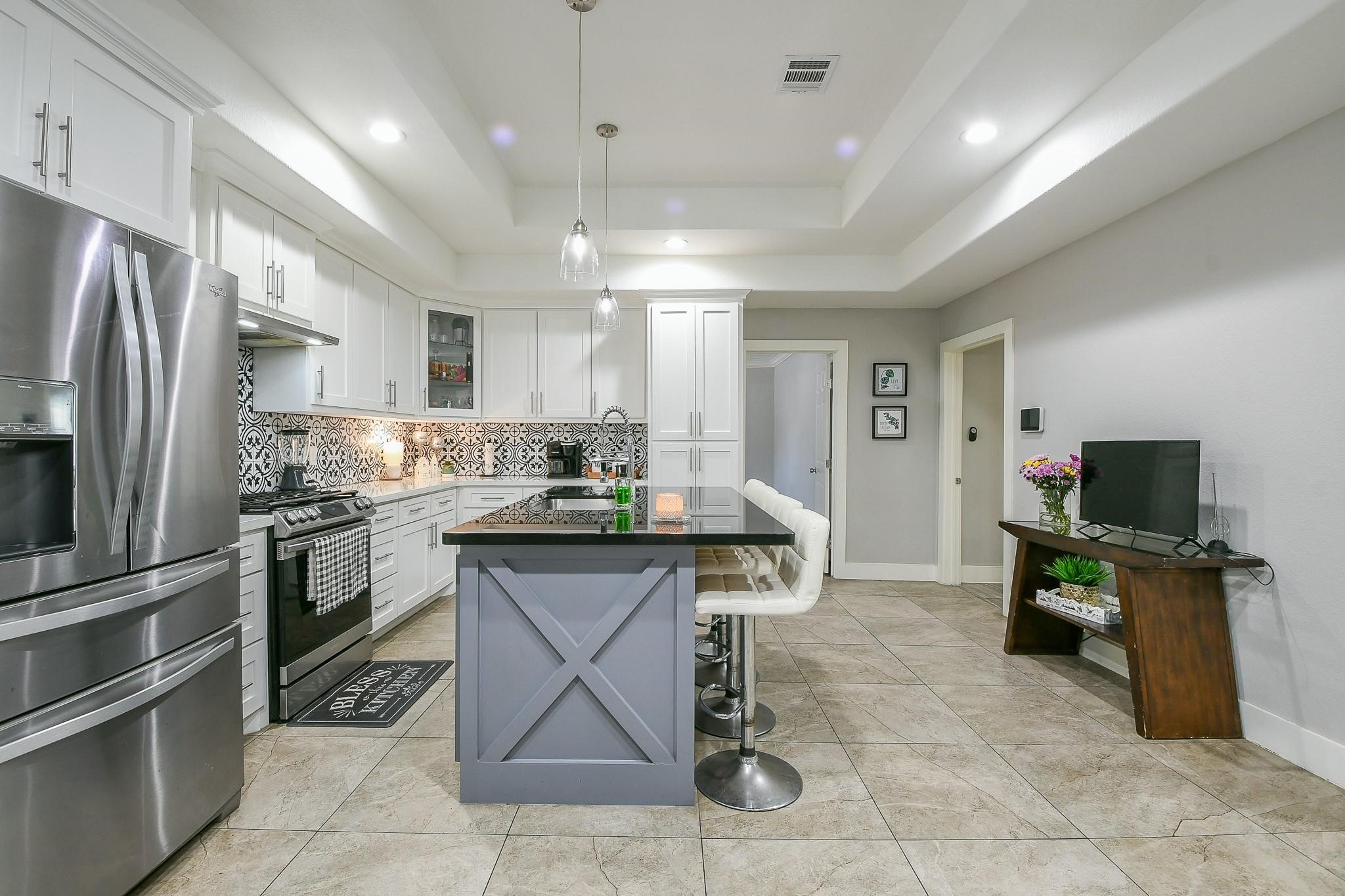 910 11th Street South Houston, TX 77587 - Photo 9 of 32 a kitchen with granite countertop a refrigerator a stove top oven and a sink