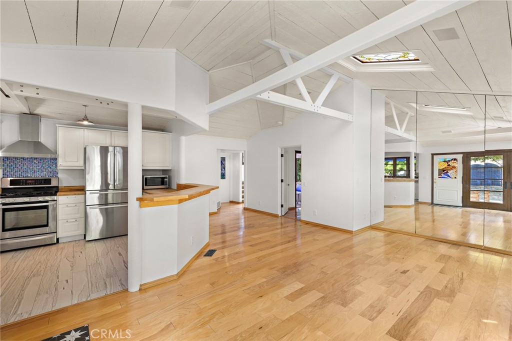 490 Agate Street Laguna Beach, CA 92651 - Photo 14 of 38 a large white kitchen with wooden floors and stainless steel appliances