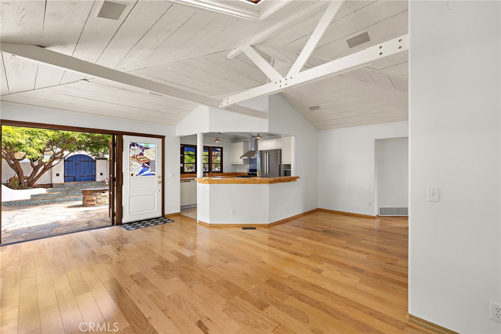 490 Agate Street Laguna Beach, CA 92651 - Photo 18 of 38 a view of an empty room and kitchen with wooden floor and windows