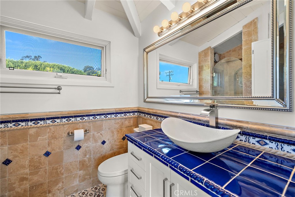 490 Agate Street Laguna Beach, CA 92651 - Photo 28 of 38 a bathroom with a sink a toilet and a mirror