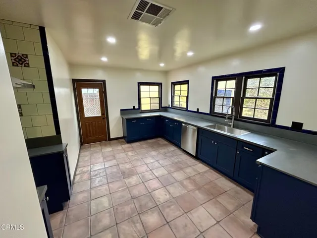 a large kitchen with sink and a large window