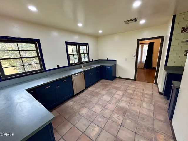 a large kitchen with a sink a large window and stainless steel appliances