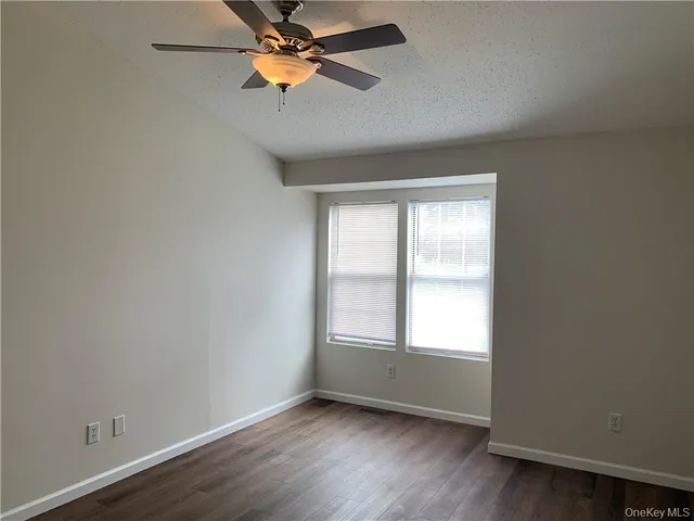 an empty room with a window and a fan