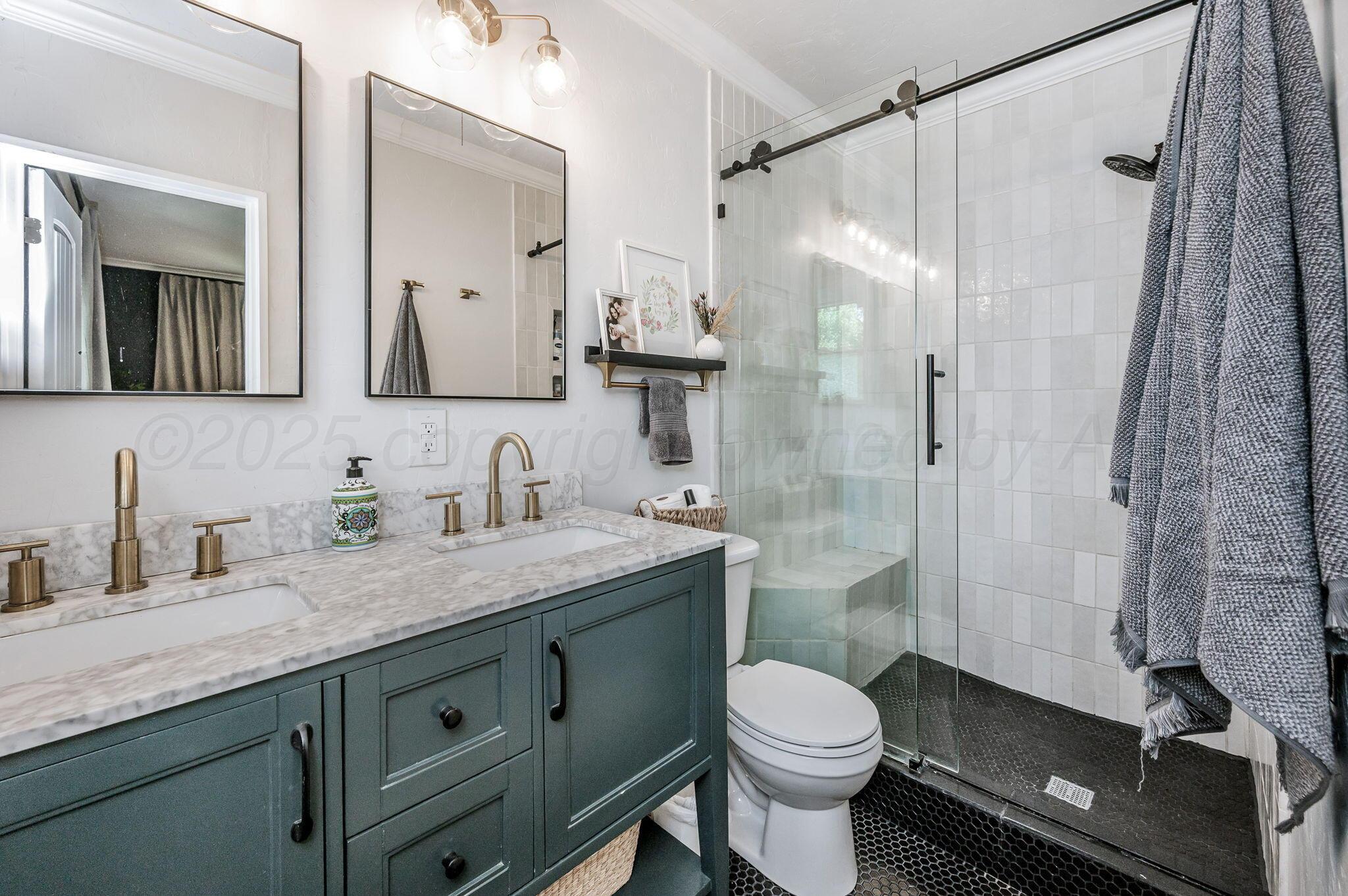 501 Sunset Terrace Amarillo, TX 79106 - Photo 12 of 21 a bathroom with a granite countertop sink toilet a mirror a shower and vanity