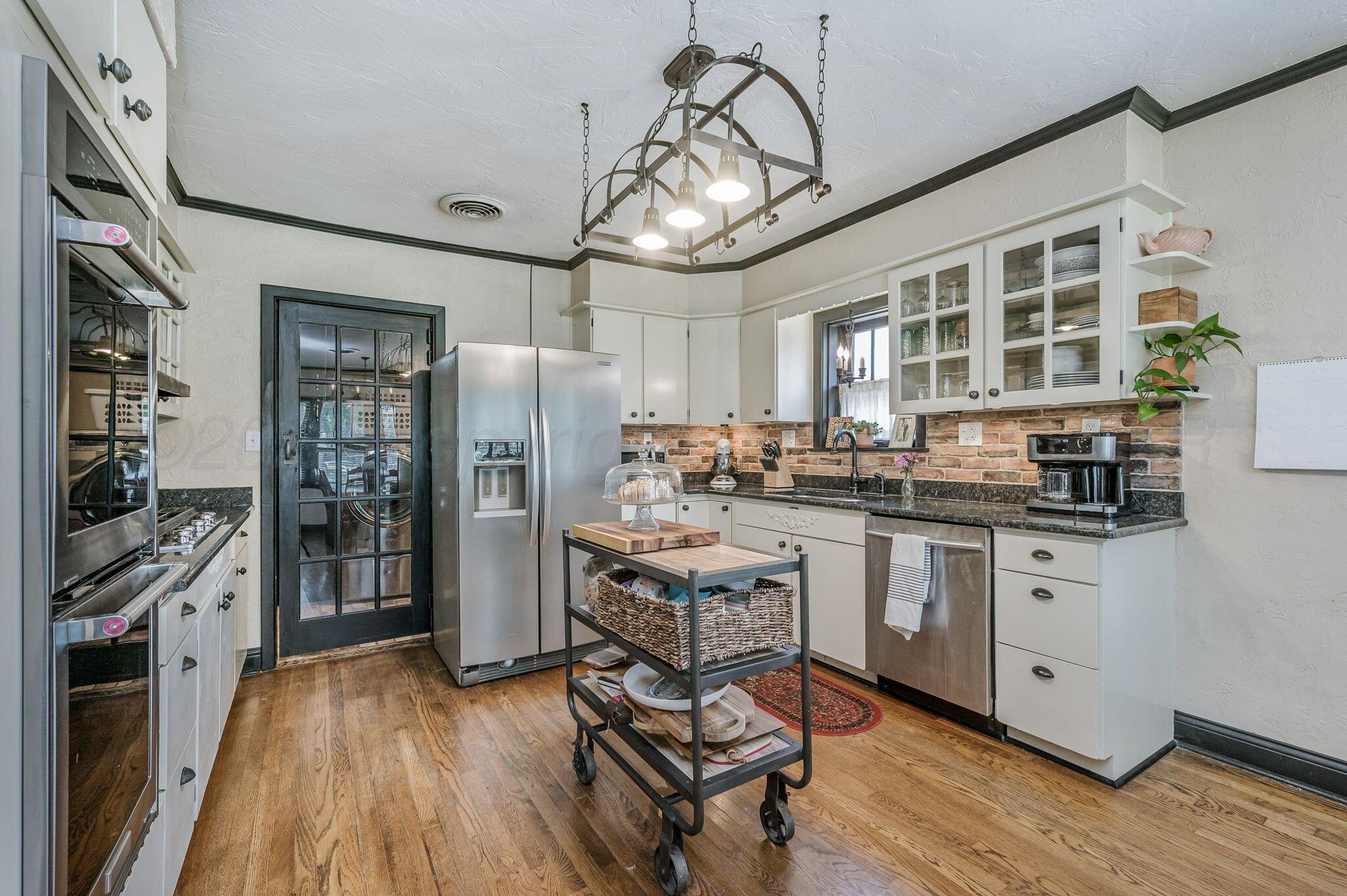 501 Sunset Terrace Amarillo, TX 79106 - Photo 7 of 21 a kitchen with stainless steel appliances granite countertop a stove refrigerator and cabinets
