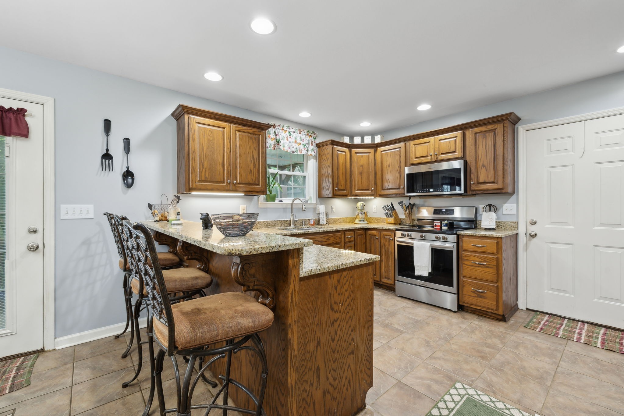1550 Beech Bottom Road Watertown, TN 37184 - Photo 8 of 38 a kitchen with kitchen island granite countertop wooden cabinets and stainless steel appliances