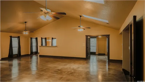 a view of an empty room with window and wooden floor
