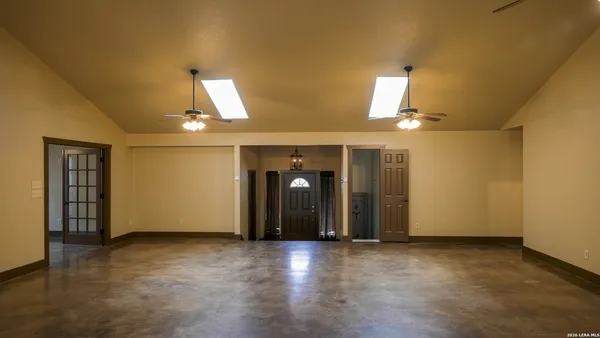 an empty room with wooden floor and natural light