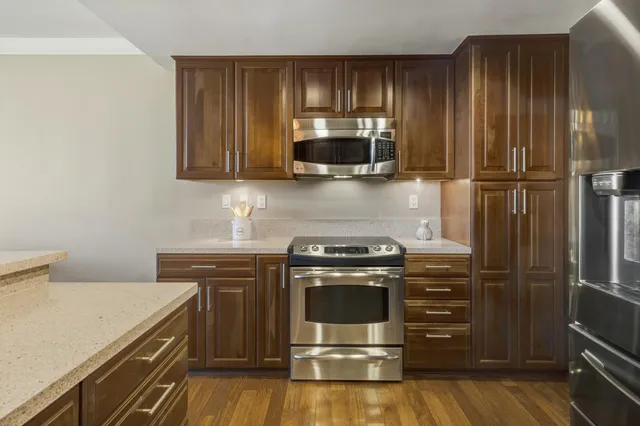 a kitchen with wooden cabinets and stainless steel appliances