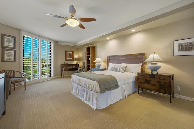 a spacious bedroom with a bed and a chandelier