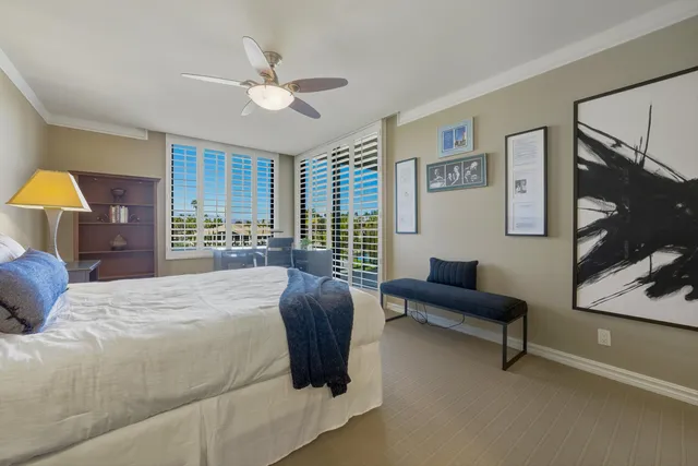 a bedroom with a bed couch and a large window