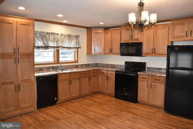a kitchen with granite countertop a refrigerator stove top oven and sink