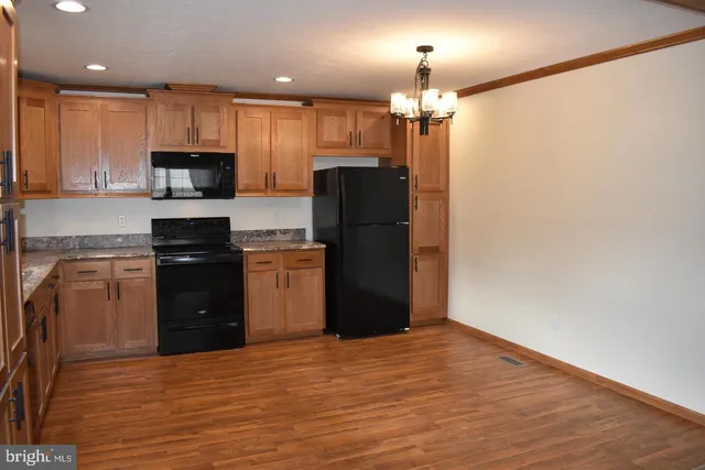 a kitchen with a refrigerator a stove top oven and sink
