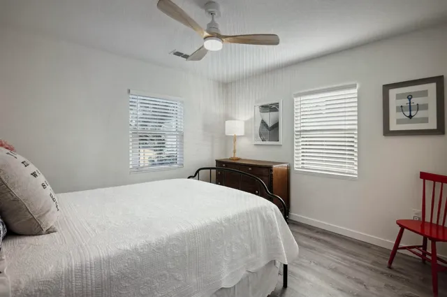 a bathroom with a granite countertop sink a mirror a bathtub and shower