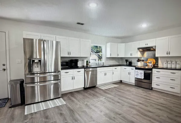 a kitchen with granite countertop stainless steel appliances and wooden cabinets