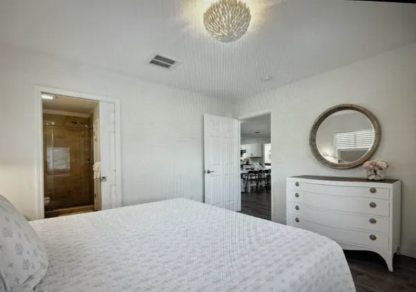 a bedroom with a large bed and wooden floor