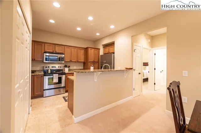 a kitchen with stainless steel appliances granite countertop a refrigerator and a stove top oven