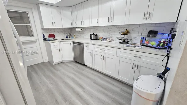 a kitchen with a sink cabinets and wooden floor