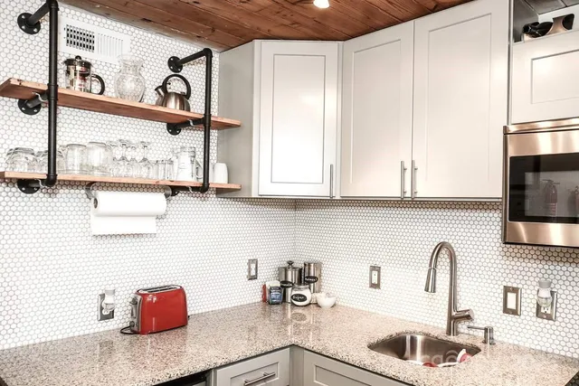 a kitchen with stainless steel appliances granite countertop a sink and a white cabinets