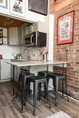 a kitchen with stainless steel appliances a table chairs in it and wooden cabinets